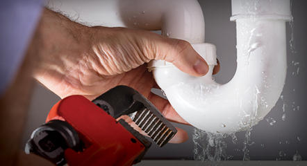 Plumber fixing a leaky pipe in a Raleigh, NC home