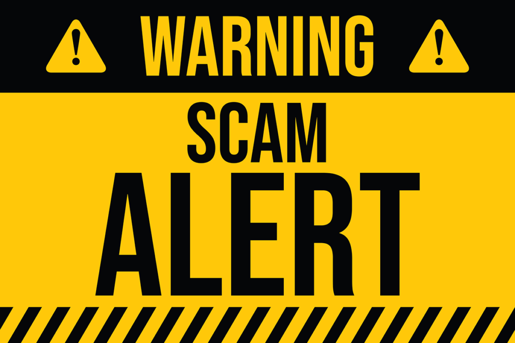 A sign reading "Warning, Scam Alert"