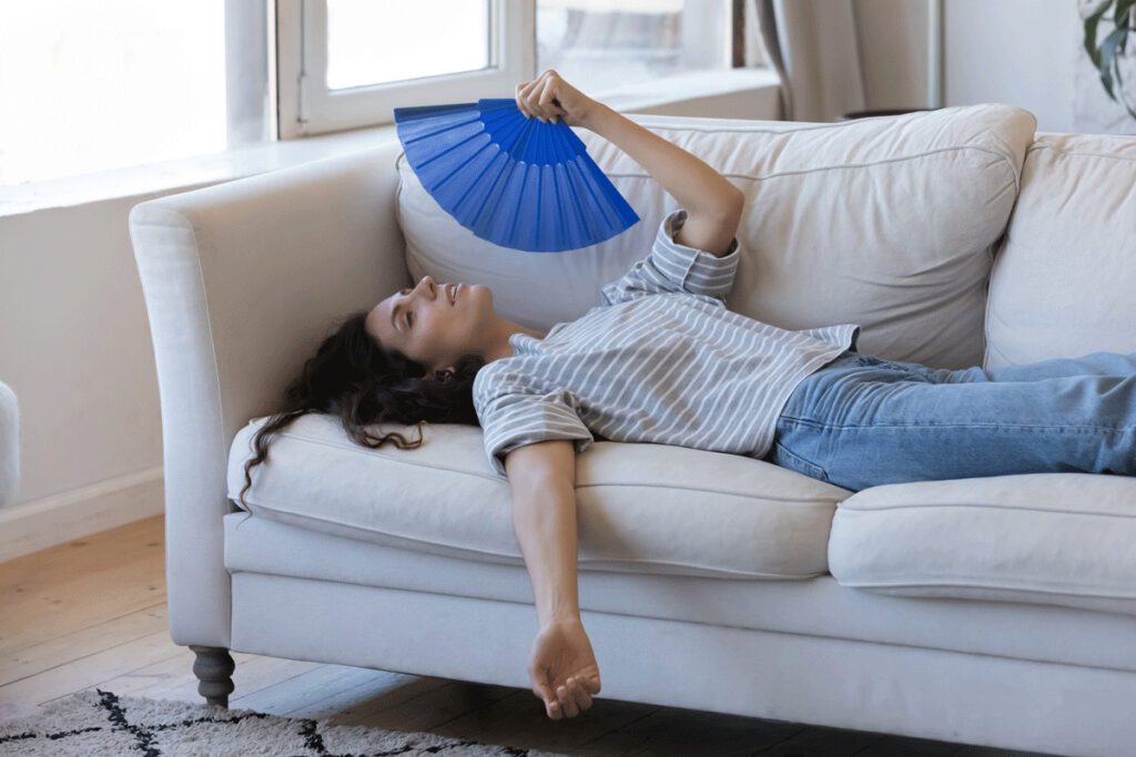 Woman fanning herself on a couch